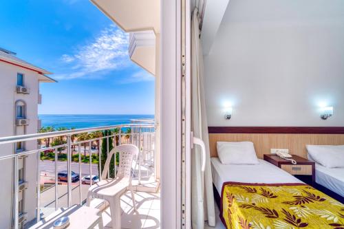 una camera da letto con un letto e un balcone con vista di Kleopatra Melissa Hotel a Alanya