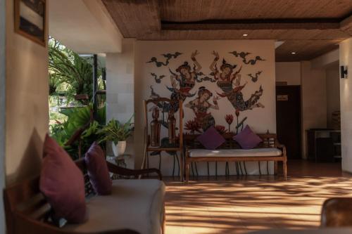 a living room with a mural on the wall at Dedary Resort & Spa Ubud by Ini Vie Hospitality in Ubud