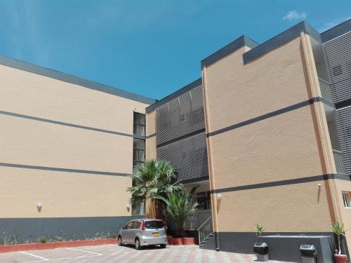 a building with a car parked in front of it at Home Inn Self-Catering in Windhoek