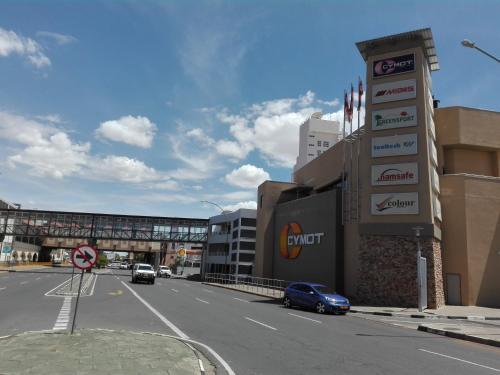 a view of a street with a building and cars on the road at Home Inn Self-Catering in Windhoek