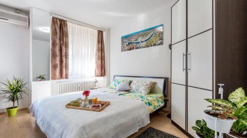 a bedroom with a bed with a tray of fruit on it at Lake Side Apartments by ZagrebRent in Zagreb