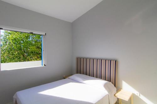 コルフォスにあるAllegre Complexの白いベッドルーム(ベッド1台、窓付)