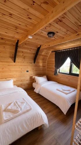 two beds in a room with a wooden ceiling at Deniz Bungalov samsun in Samsun
