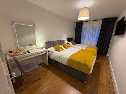 a bedroom with a bed and a desk and a mirror at Maya's Lodge in Dublin