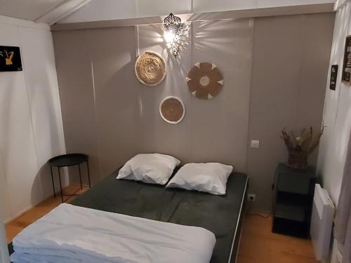 a small bedroom with a bed and a light at Chalets du Causse 4 in Gelle