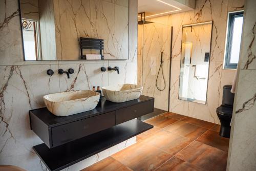a bathroom with two sinks on a counter with a mirror at Retreat 10 in Beccles