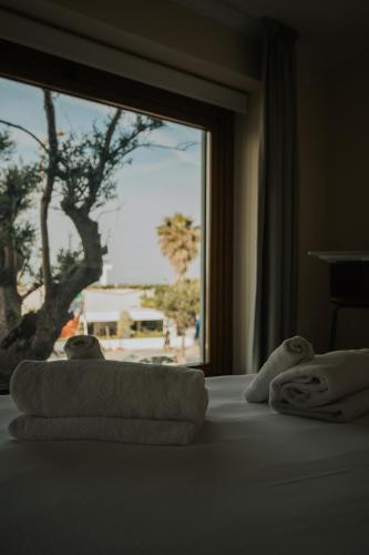 a bedroom with towels on a bed with a window at Afrodite Luxury Residence & Spa in Pescara