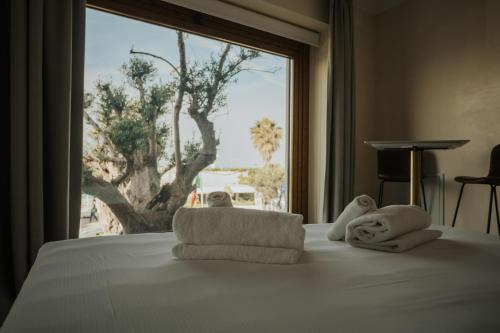 a bedroom with a bed with towels and a window at Afrodite Luxury Residence & Spa in Pescara