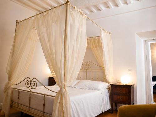 a bedroom with a canopy bed with curtains at Dimora storica - Palazzo Barabesi in Siena