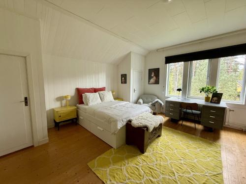 a bedroom with a bed and a desk and a window at SwedenWoods in Hagfors