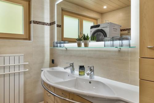 a bathroom with a sink and a microwave at Grundwert Apartment in Sonntag