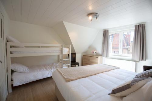 a bedroom with two bunk beds and a window at Queen Astrid in Ypres