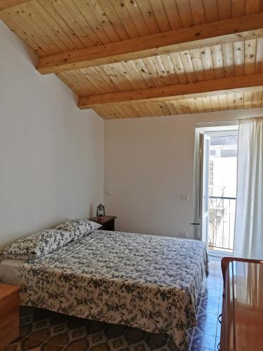 a bedroom with a bed and a window at Santanna106 in Santa Domenica