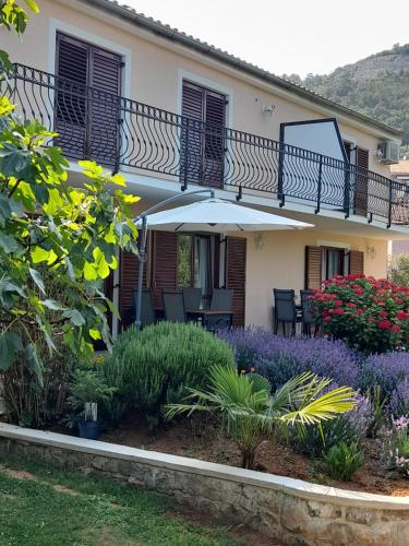 a house with an umbrella and some flowers at Villa Marija in Opatija