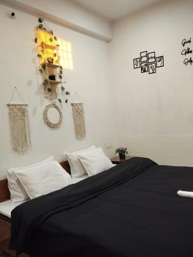 a bedroom with a bed with black sheets and white pillows at peak&valley homestay in Dharmsāla
