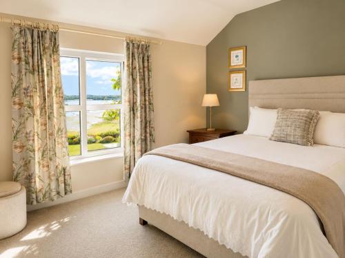 a bedroom with a large bed and a window at Corrib View Country House in Killarone