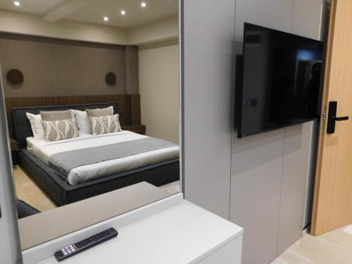 a bedroom with a bed with a mirror and a television at SFERA Boutique Rooms in Iaşi