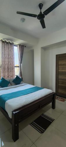 a bedroom with a bed with a ceiling fan at Sky Light Mysore in Mysore South