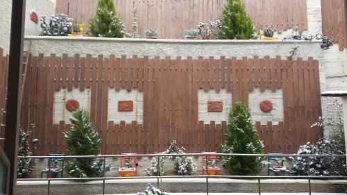 uma cerca de madeira com árvores de Natal em frente a um edifício em Nidimos Hotel em Delfoi