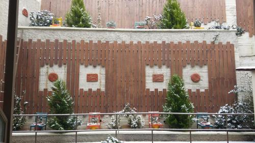 a wooden fence with christmas trees in front of a building at Nidimos Hotel in Delfoi