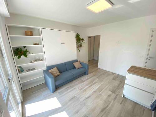 a living room with a blue couch in a room at Studio Artemisia in Grado
