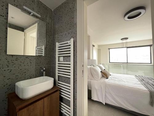 a bathroom with a sink and a bed and a mirror at Athenean Gem Near Metro Mall in Athens