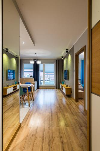 a living room with a table and a dining room at Apartament Waterside in Giżycko