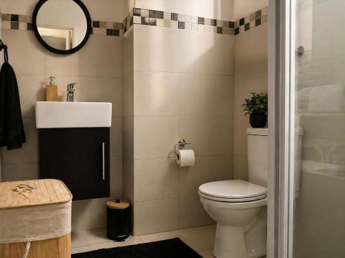 a bathroom with a toilet and a sink and a mirror at Beach, Restaurants, Shopping, Park, Pier - nearby in Durban
