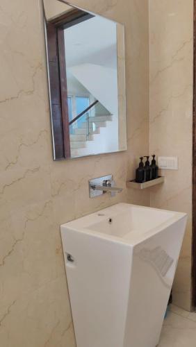a bathroom with a white sink and a mirror at Luxury Chalet Villa in Shimla