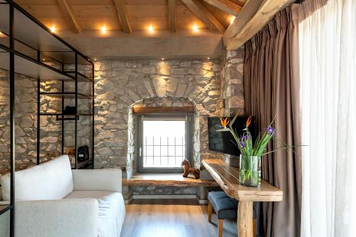 a living room with a stone wall with a window at Evoras Boutique Hotel in Xirokámbion