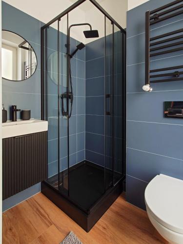a bathroom with a shower with blue tiles at Bemma Apart in Wrocław