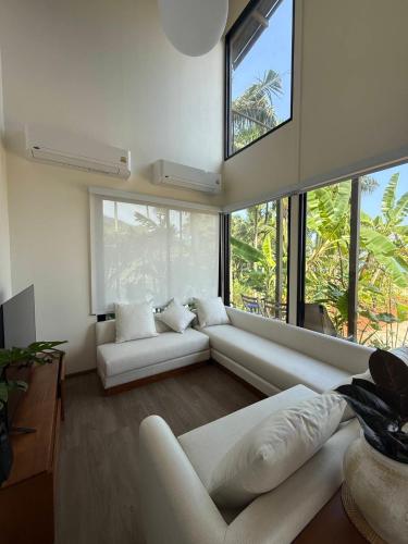 a living room with white furniture and large windows at Wave & Vibes Koh chang in Ban Chek Bae (1)