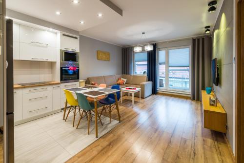 a kitchen and living room with a table and chairs at Apartament Waterside in Giżycko