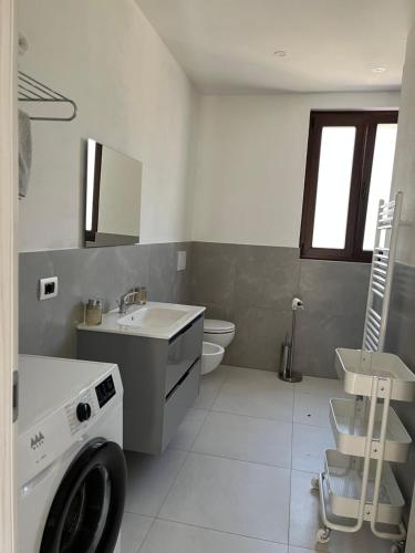 a bathroom with a washing machine and a sink at Appartamento sole e luna in Dumenza