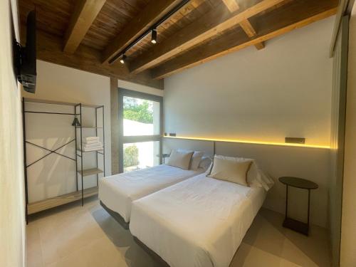 a bedroom with a white bed and a window at Hotel SPA John Te Lo Busca in Castrojeriz