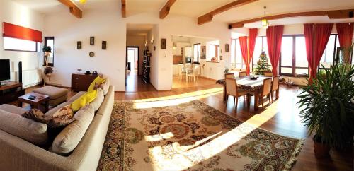 a living room with a couch and a dining room at Jasmine Residence in Prejmer