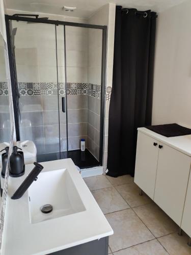 a bathroom with a white sink and a shower at Maison de campagne in Aubagne