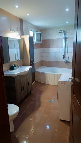 a bathroom with a tub and a sink and a toilet at Lyra's house in Skiathos