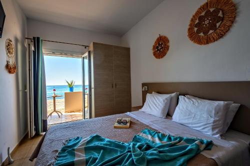 a bedroom with a bed with a view of the ocean at Fodele Beachfront Apts in Fodele