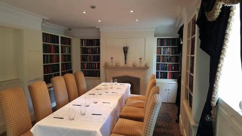 a dining room with a table with chairs and a fireplace at Wildes Inns in Chesterfield
