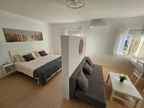 a small bedroom with a bed and a couch at Jingtu Wellness & Spa Resort in Comares