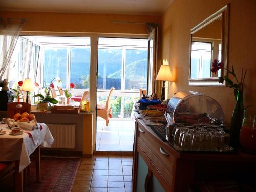eine Küche mit einer Theke, einem Tisch und einem Fenster in der Unterkunft Ferienweingut Wolfgang Adamy in Kinheim