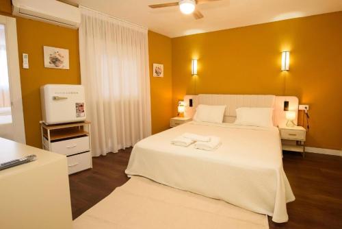 a bedroom with a white bed with two towels on it at Casa Boutique Con Terraza Ideal in Dos Hermanas