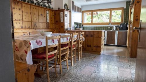 a kitchen with wooden cabinets and a table with chairs at Chalet authentique à Ovronnaz in Leytron