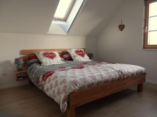 a bedroom with a bed with red and white comforter at Gîte La Grange in Chapelle
