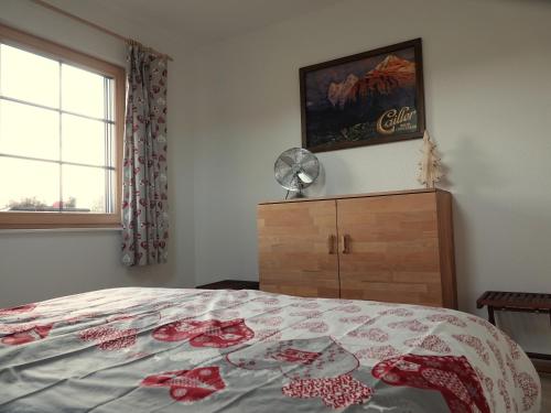 a bedroom with a bed and a dresser and a window at Gîte La Grange in Chapelle