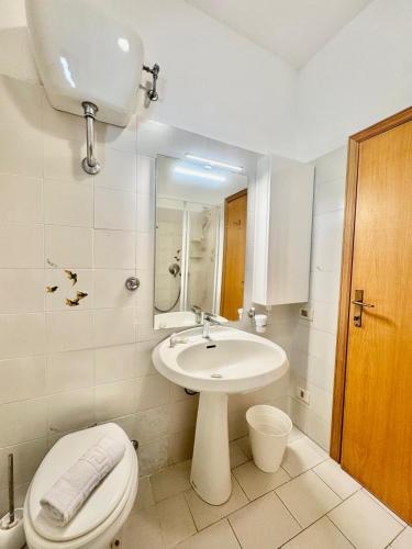 a white bathroom with a toilet and a sink at Mare Mio Talamone in Talamone