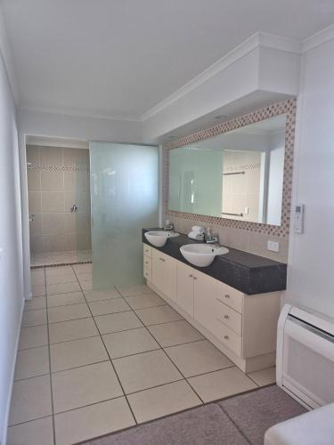 a bathroom with two sinks and a large mirror at Mooloolaba Waterfront Luxury in Mooloolaba