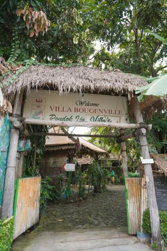 an entrance to a building with a thatch roof at Pondok IJo Guesthouse in Yogyakarta