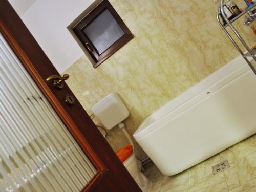a bathroom with a toilet and a television on the wall at Jasmine Residence in Prejmer